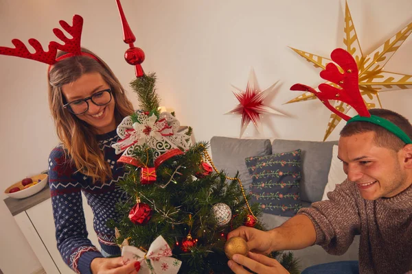 Ευτυχισμένο ζευγάρι διακόσμηση του δέντρου για το νέο έτος / παραμονή των Χριστουγέννων. — Φωτογραφία Αρχείου