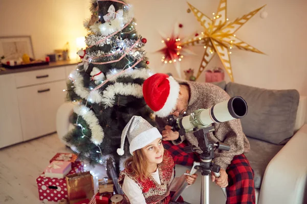 Vater und Tochter schauen zu Weihnachten ins Fernrohr / Neu — Stockfoto