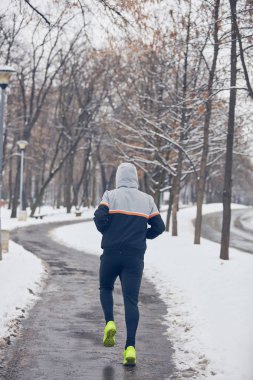 Soğuk bir kış karlı gün açık havada adam jogging.
