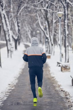Soğuk bir kış karlı gün açık havada adam jogging.
