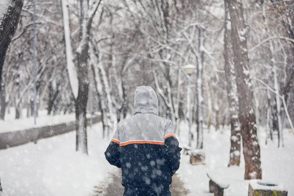 Hombre corriendo en un frío invierno nevado día al aire libre . — Foto de Stock