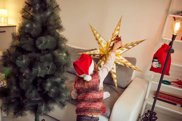 Çocuk kız Noel/yeni yıl için parlak dekorasyon hazırlanıyor — Stok fotoğraf
