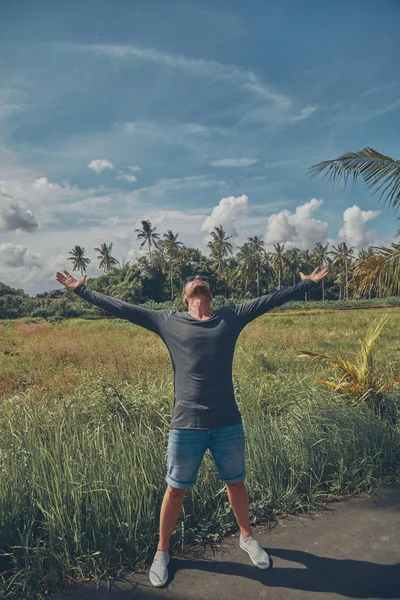 Homem desfrutando de clima tropical com os braços abertos . — Fotografia de Stock