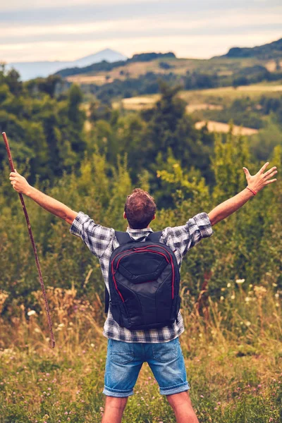 Man hiker with arms wide open in the field. — Stock Photo, Image