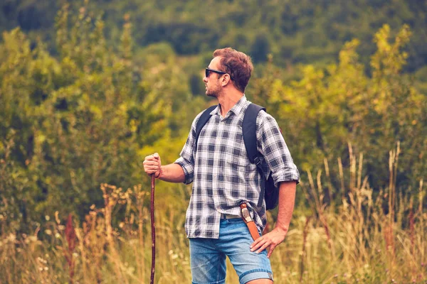 Hiker posing with knife on the belt in a meadow. — Stock Photo, Image