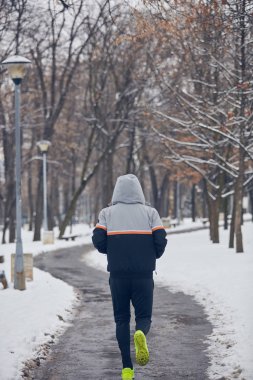 Soğuk bir kış karlı gün açık havada adam jogging.