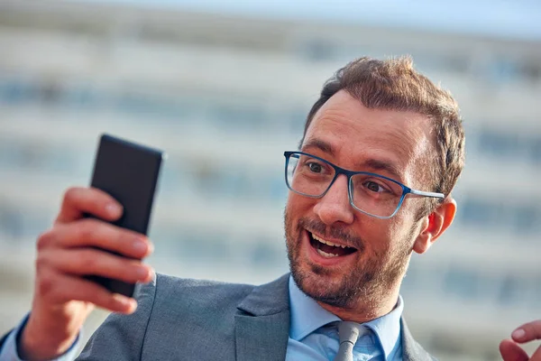 Empresario usando su smartphone en la calle . —  Fotos de Stock