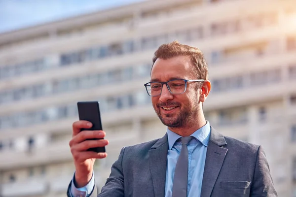 Empresario usando su smartphone en la calle . —  Fotos de Stock