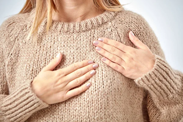 Young woman with heart problem holding chest.