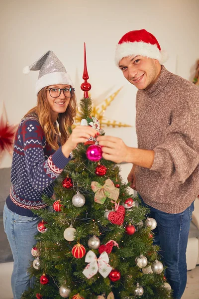 Glückliches Paar schmückt Baum für Neujahr / Heiligabend. — Stockfoto