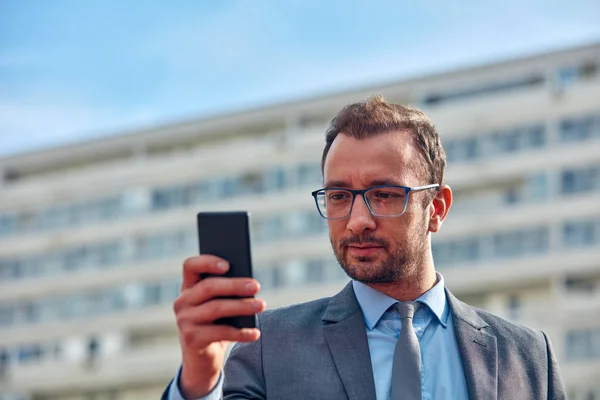 Empresario usando su smartphone en la calle . — Foto de Stock