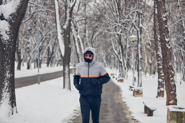 Άνθρωπος τζόκινγκ σε μια κρύα χειμωνιάτικη μέρα σε εξωτερικούς χώρους. — Φωτογραφία Αρχείου