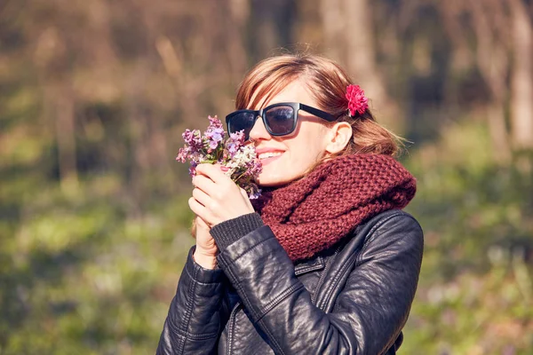 Cute young girl smelling nice bouquet of flowers in nature. — Stock Photo, Image