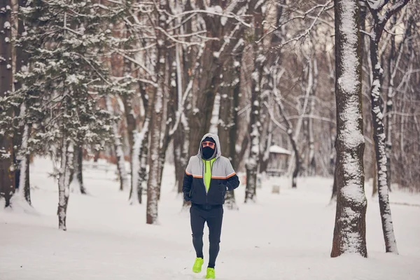 Чоловік бігає в холодний зимовий сніжний день на відкритому повітрі . — стокове фото