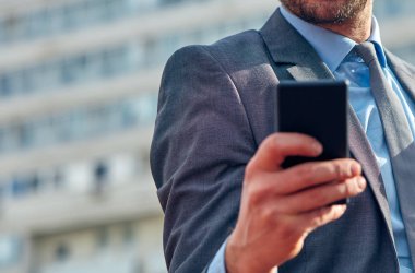 İş adamı sokakta onun Smartphone kullanarak.