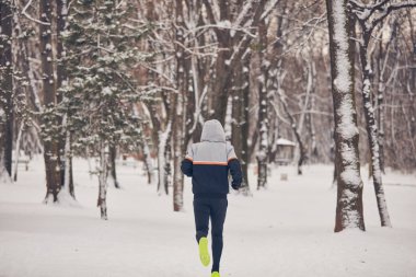 Soğuk bir kış karlı gün açık havada adam jogging.