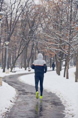 Soğuk bir kış karlı gün açık havada adam jogging.