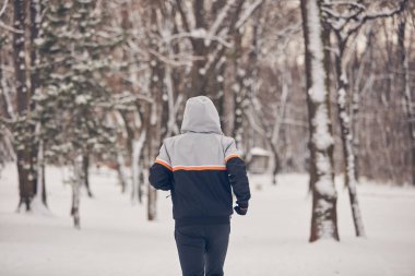 Soğuk bir kış karlı gün açık havada adam jogging.