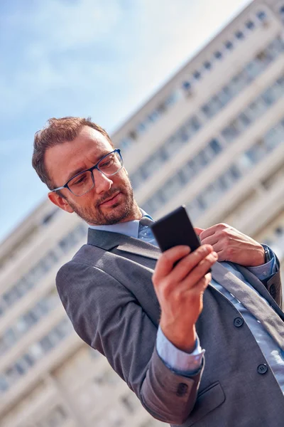 Empresario usando su smartphone en la calle . — Foto de Stock