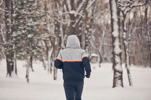Человек бегает в холодный зимний снежный день на открытом воздухе . — стоковое фото
