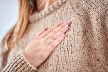 Kalp sorunu olan genç kadın göğüs tutarak.