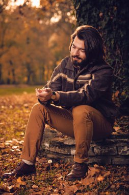 Parkta el saatine bakan adam.