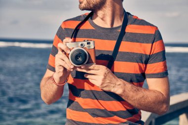Bir okyanus/deniz tatil Vintage Film Kamera kullanan adam.