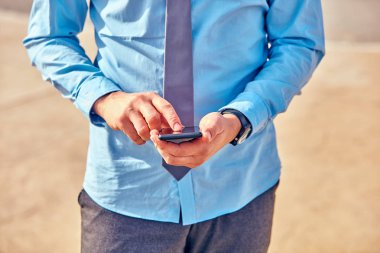 İş adamı sokakta onun Smartphone kullanarak.