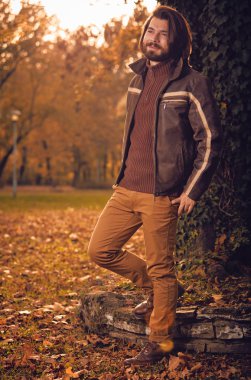 Sonbahar renkli parkta ağacın yanında poz adam.