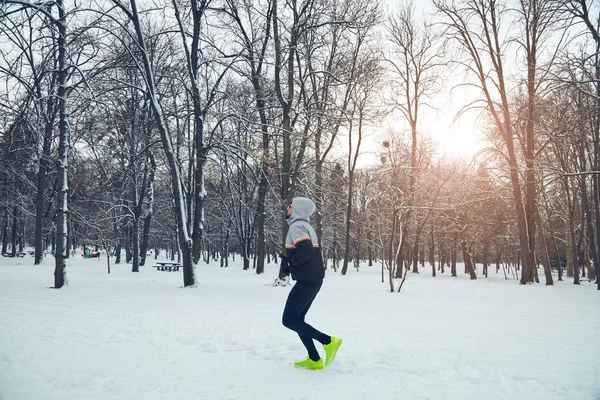 Człowiek, jogging w parku śnieg i zimno. — Zdjęcie stockowe