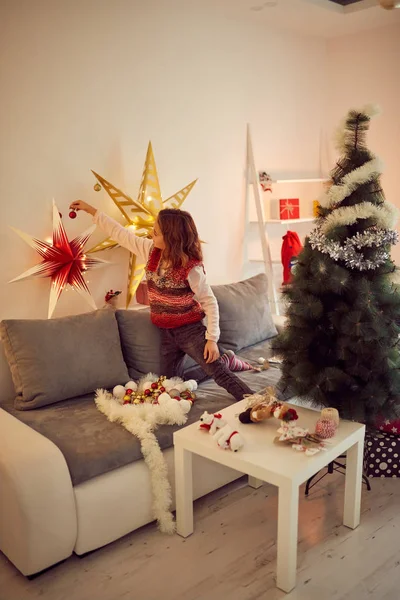 Child girl preparing shiny decoration for Christmas / New Year's — Stock Photo, Image