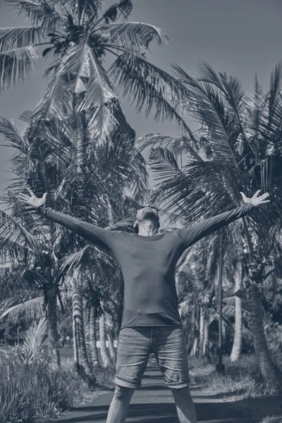 Homem desfrutando de clima tropical com os braços abertos . — Fotografia de Stock