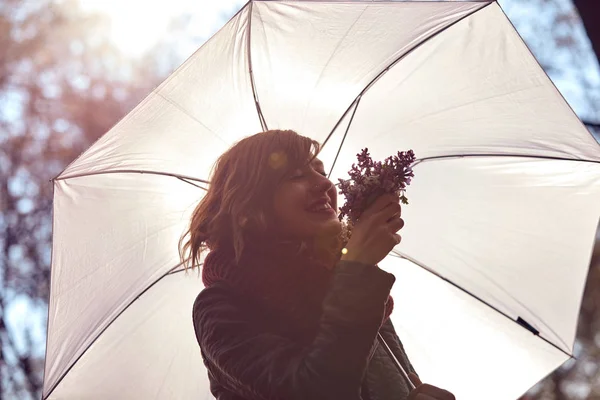 Schattig jong meisje ruiken mooi boeket van bloemen in de natuur. — Stockfoto