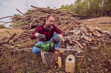 Testere ile kesme woods yığını ile oduncu.