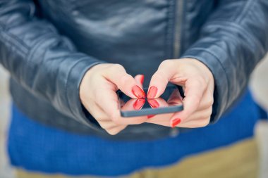 Sokakta modern akıllı telefon kullanan bir kadın..