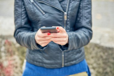 Sokakta modern akıllı telefon kullanan bir kadın..