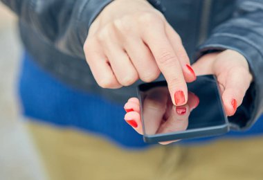 Sokakta modern akıllı telefon kullanan bir kadın..