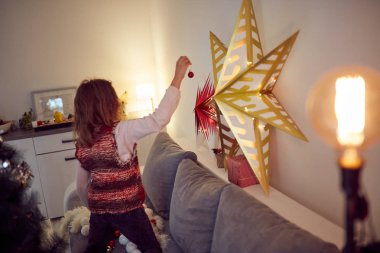 Çocuk kız Noel/yeni yıl için parlak dekorasyon hazırlanıyor