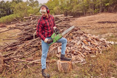 Testere ile kesme woods yığını ile oduncu.