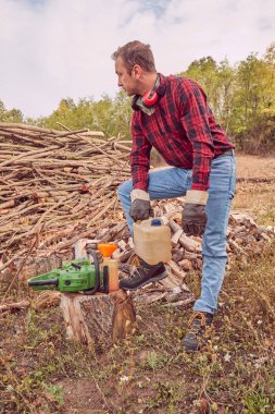 Testere ile kesme woods yığını ile oduncu.