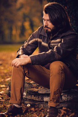 Sonbahar renkli parkta ağacın yanında poz adam.