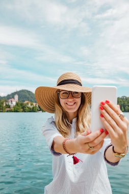 Smartphone kullanarak göl kenarında şirin kız.