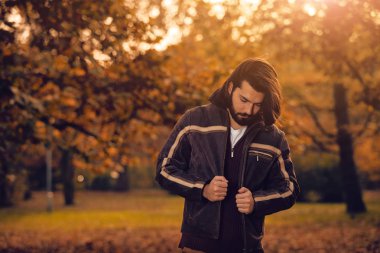 Yakışıklı genç adam giyen deri ceket Sonbahar sezonunda / soğuk hava.