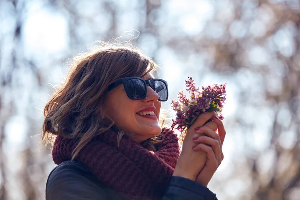 Cute young girl smelling nice bouquet of flowers in nature. — Stock Photo, Image