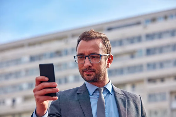 Empresario usando su smartphone en la calle . — Foto de Stock