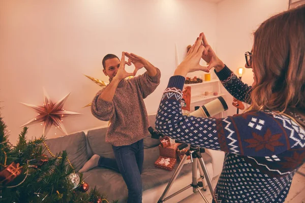 Paar mit Teleskop und Herz - Gestalt genießt Weihnachten / Neu — Stockfoto