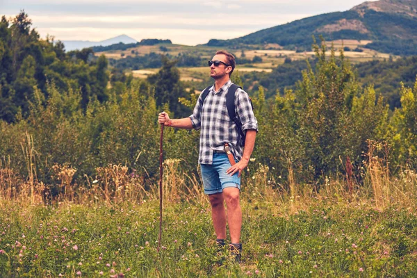 Hiker posing with knife on the belt in a meadow. — Stock Photo, Image