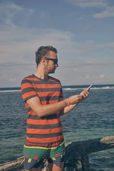 Hombre usando celular en la playa del océano . —  Fotos de Stock