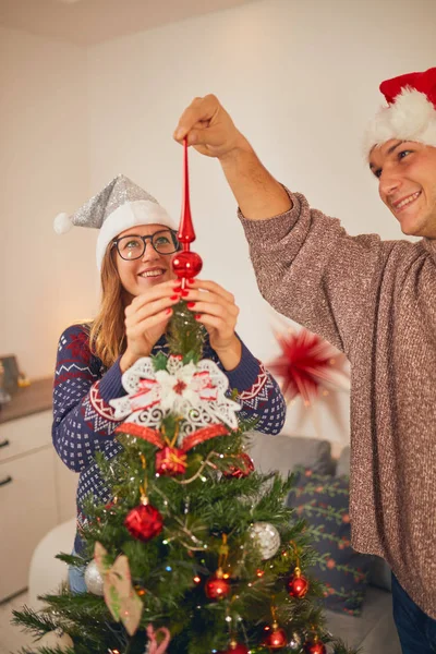 Ευτυχισμένο ζευγάρι διακόσμηση του δέντρου για το νέο έτος / παραμονή των Χριστουγέννων. — Φωτογραφία Αρχείου