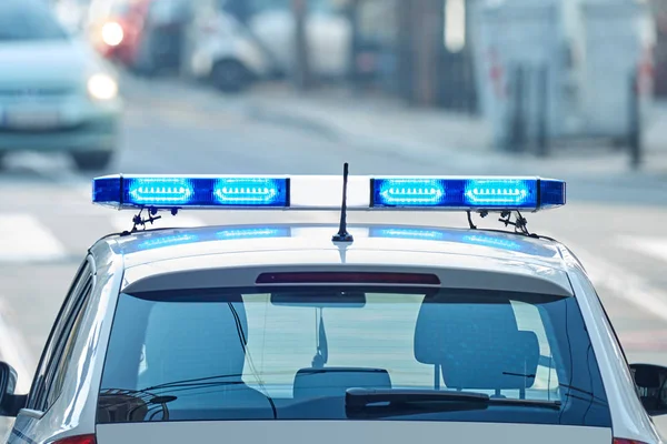 Samochód policyjny z niebieskimi światłami na scenie zbrodni w ruchu/Urba — Zdjęcie stockowe